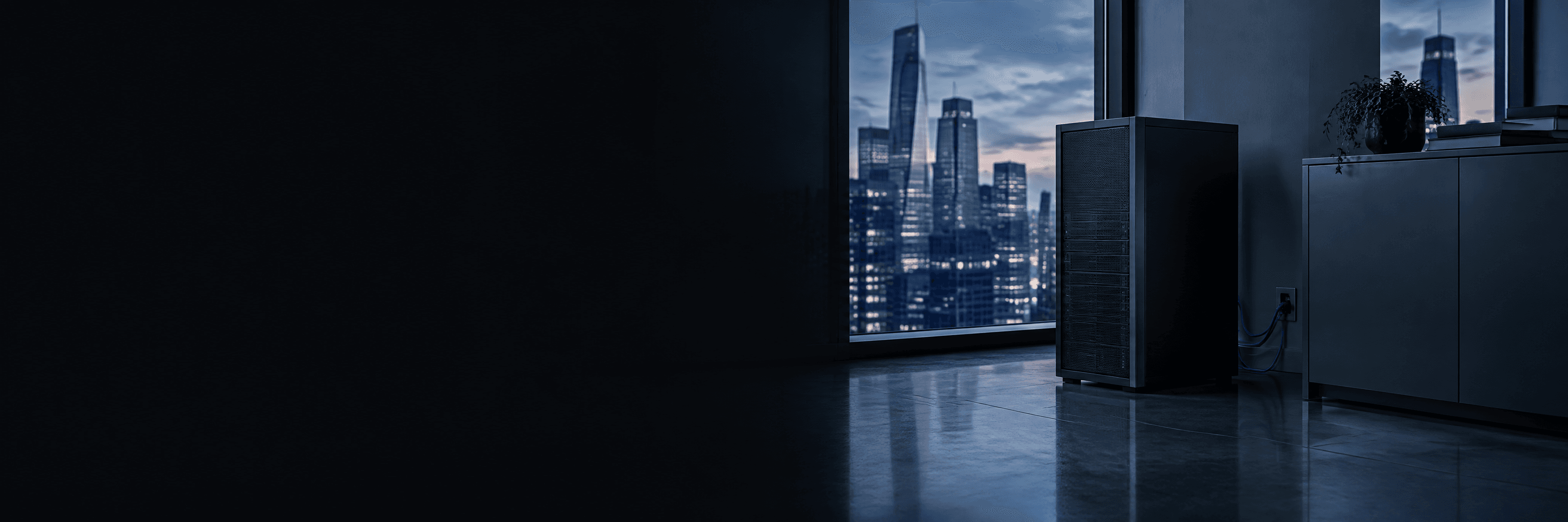 A quiet server tower in the corner of an office at dusk, cabled to a wall port